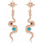 Rose gold snake-shaped earrings with turquoise stones on a white background