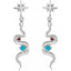 Silver earrings with star tops, turquoise stones, and red accents on a white background