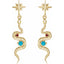 Gold snake-shaped earrings with star tops and gemstones on a white background