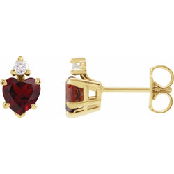 Gold earrings with red heart-shaped gemstones on a white background