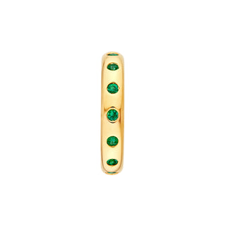 A emerald eternity band made in 14k yellow gold with round emeralds set around the ring. 