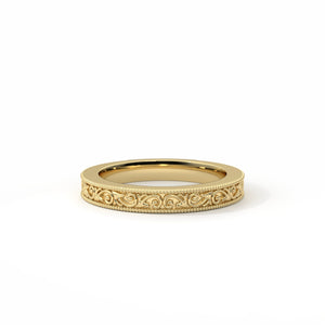Gold ring with intricate design on a white background