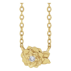 Gold necklace with a floral pendant featuring a diamond on a white background