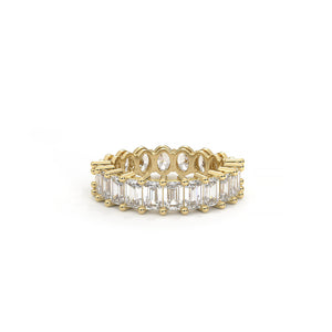 Gold ring with emerald-cut diamonds on a white background