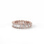Rose gold ring with emerald-cut diamonds on a white background