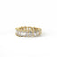 Gold ring with emerald-cut and round diamonds on a white background