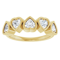 Gold ring with heart-shaped diamond stones on a white background