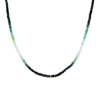 A emerald necklace with an ombre look, created with different shaded green and gold bead spacing. 
