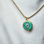 Necklace with a Hamsa hand pendant on a textured white background