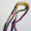 A round beaded smooth beaded rainbow tourmaline hand knotted with matching rainbow colored silk string. 