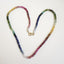 A round beaded smooth beaded rainbow tourmaline hand knotted with matching rainbow colored silk string. Finished with solid gold wheel clasp. 