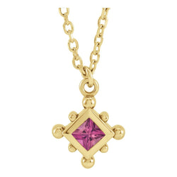 Gold necklace with a pink gemstone pendant on a white background