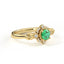 Gold ring with a green gemstone on a white background