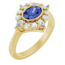 Gold ring with a blue gemstone and diamond accents on a white background