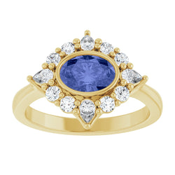 Gold ring with a blue gemstone and diamond accents on a white background