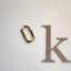 A small oval solid gold carabiner lock connector.