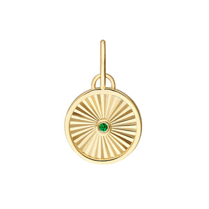A round pendant with a ray design going toward a center emerald. The emerald is bezel set along with a plain gold boarder.