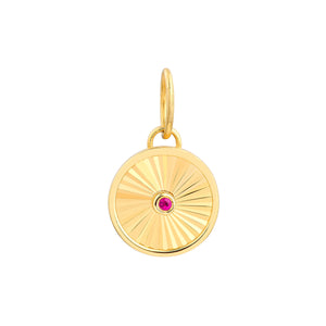 A round pendant with a ray design going toward a center ruby. The ruby is bezel set along with a plain gold boarder.
