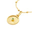 A round pendant with a ray design going toward a center emerald. The emerald is bezel set along with a plain gold boarder.