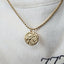 A round coin pendant with a side profile of a roaring lion. The lion has detailed manes and features, very realistic. 