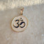 A round coin pendant with reversable two sides. One side is navy enameled "OM" sign, and on the other it is a lotus with a "OM" sign carved in the flower.