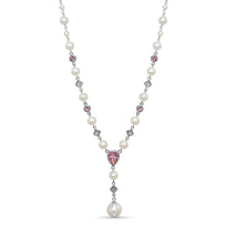 Pearl necklace with pink heart-shaped gem and silver accents on a white background