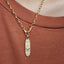 Gold necklace with a pendant on a brown background