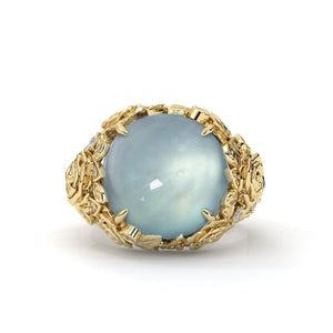 Gold ring with a large blue gemstone on a white background