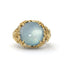 Gold ring with a large blue gemstone on a white background