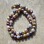 Multicolored pearl necklace on a textured beige surface