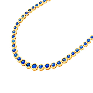 Gold necklace with blue stones on a white background