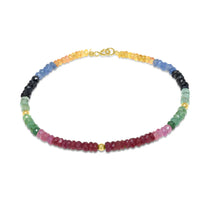 A faceted gemstone ombre beaded bracelet with three gold accents and a round clasp. 