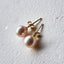 Pair of pearl earrings on a textured white surface
