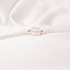 A beaded pearl necklace with oval shaped beads and gold accent finished with a center barrel shaped bead. 