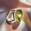A large cocktail ring with a big around face set with yellow crystals and a freshwater pearl set on top. 