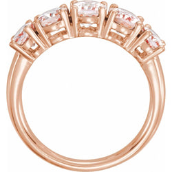 Rose gold ring with clear gemstones on a white background