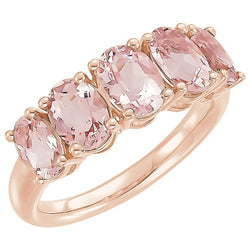 Rose gold ring with pink gemstones on a white background