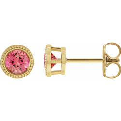 Gold earrings with pink gemstones on a white background
