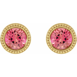 Gold earrings with pink gemstones on a white background