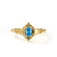Gold ring with a blue gemstone on a white background