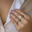 A modern gold band that is open centered with the two ends featuring pointy spear designs. 