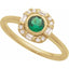Gold ring with a green gemstone and diamond accents on a white background