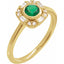 Gold ring with a green gemstone and diamond accents on a white background