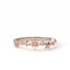 Rose gold ring with star designs and small diamonds on a white background