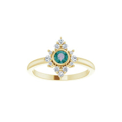 Gold ring with a green gemstone and diamond accents on a white background