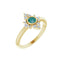 Gold ring with a green gemstone and diamond accents on a white background