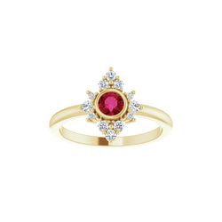 Gold ring with a red gemstone and diamond accents on a white background