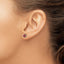 On model showing a pair of rose gold rose stud earrings with a ruby center on both. The pedals are in 14k rose gold along with the prongs and post and backing.