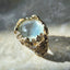 Gold ring with a large gemstone on a textured surface
