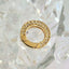 Gold ring with embedded stones on a clear crystal background